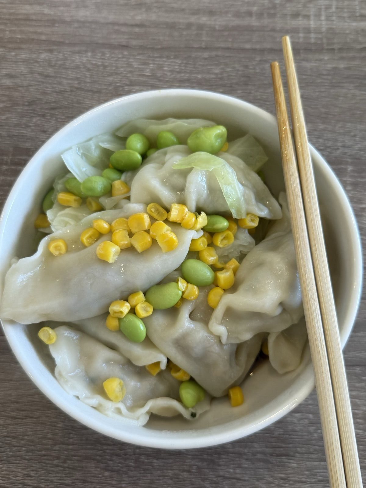 一碗饺子、玉米、毛豆和蔬菜