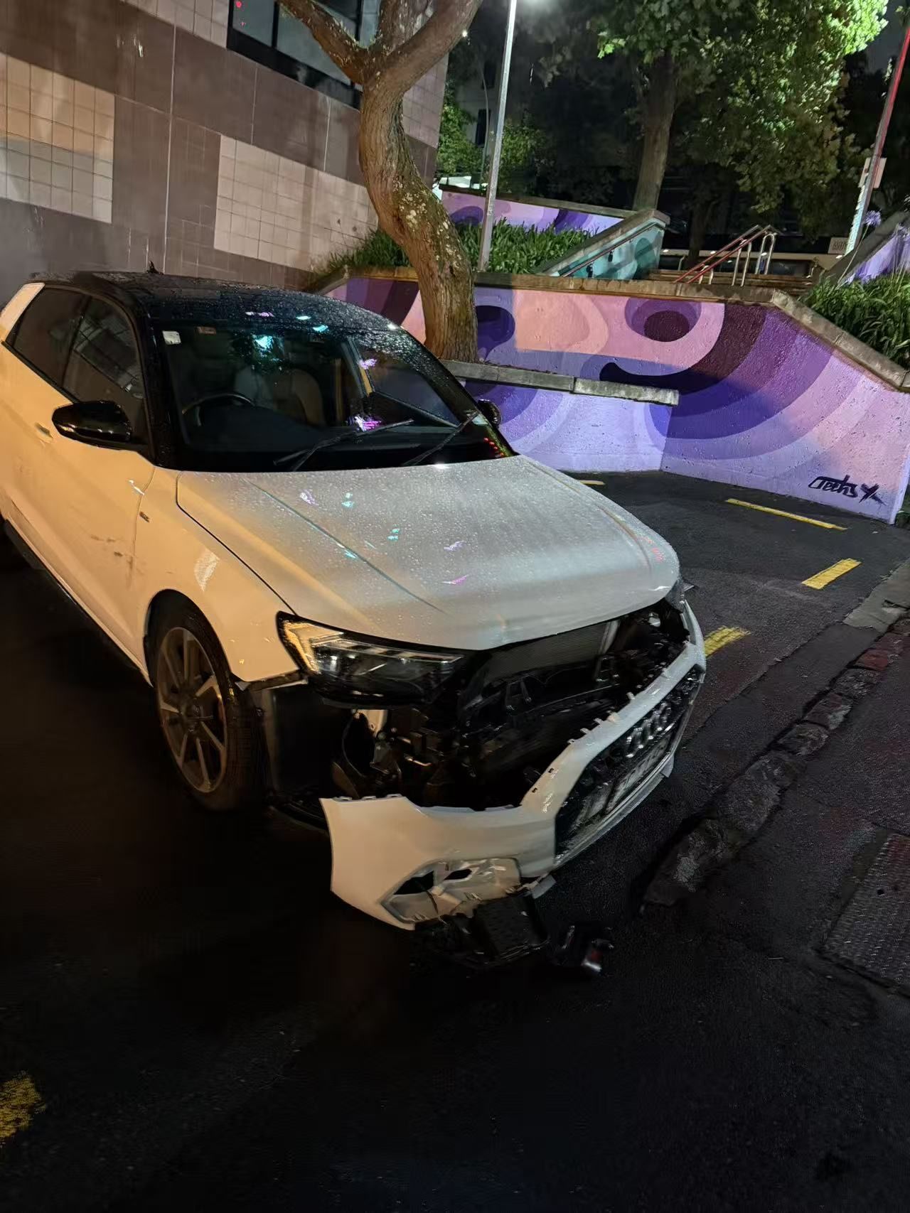 夜间停在路边、车头严重受损的白色汽车